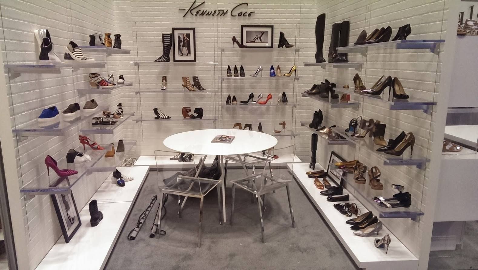 Kenneth Cole shoe display with shelves, chairs, and a table; a retail store interior.