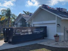 a dumpster is parked in front of a house .
