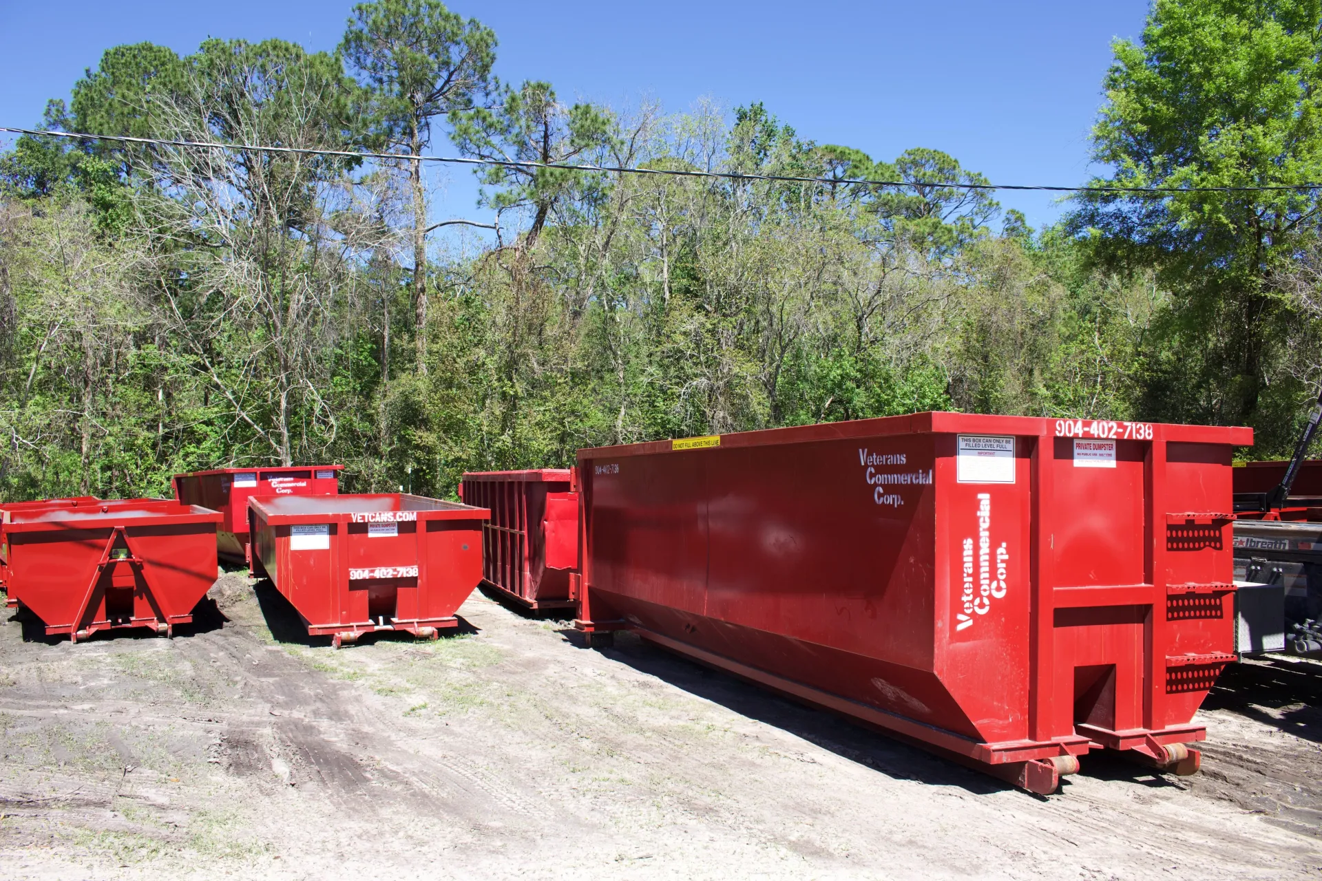 A green dumpster is parked in front of a house.
