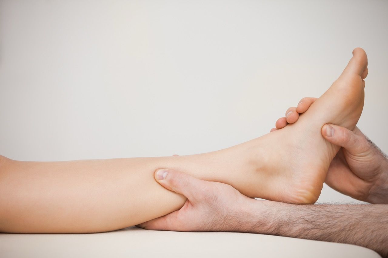 practitioner holding patient calf and foot