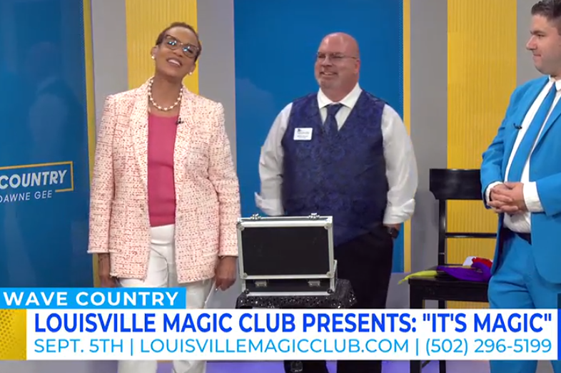 Man in blue vest next to lady in pink clothing news reporter, news segment