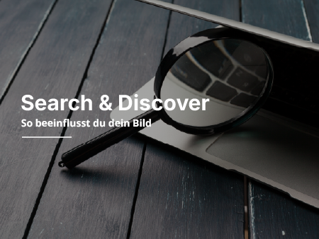 Eine Lupe liegt zwieschen einem Laptop Bildschirm.