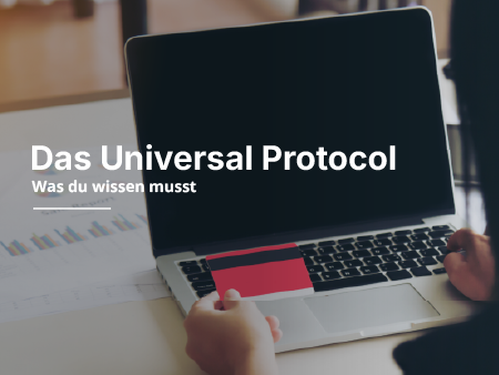 Eine rote Kreditkarte wird vor einem Laptop gezeigt.