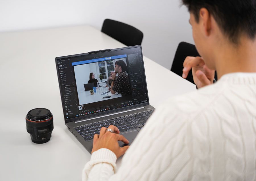 Ein Mann sitzt an einem Tisch und benutzt einen Laptop.