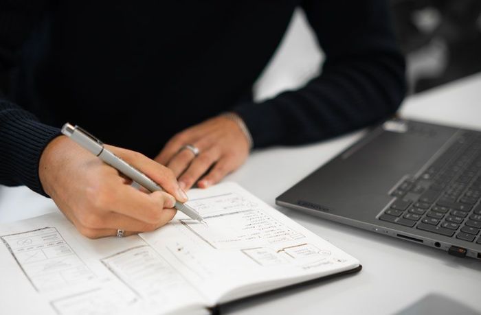 A team member at netpulse AG taking notes in a notebook during a strategy session