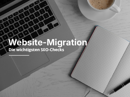 Ein Laptop, ein Notizblock und eine Kaffeetasse auf einem Schreibtisch.