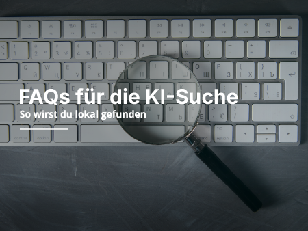 Eine Lupe liegt auf einer weissen Laptop Tastatur.