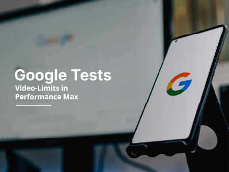 Smartphone mit Google-Logo auf Ständer, unscharfer Hintergrund eines Computerbildschirms, Text: Goog