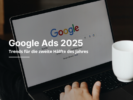 Eine Person tippt auf einem Laptop, während eine Google-Anzeige auf dem Bildschirm erscheint.