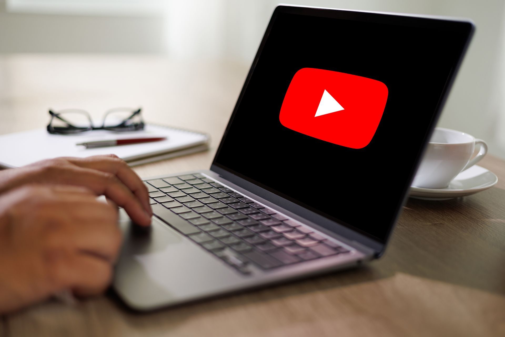 Eine Person benutzt einen Laptop mit einem youtube-Logo auf dem Bildschirm.