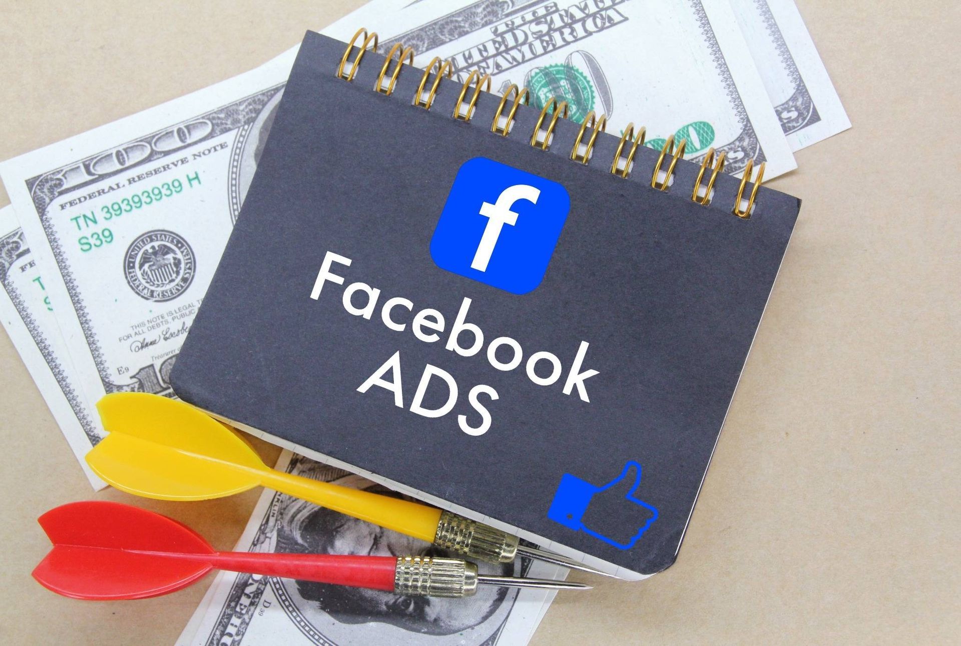 Ein Facebook Ads Notizbuch liegt auf Geld.