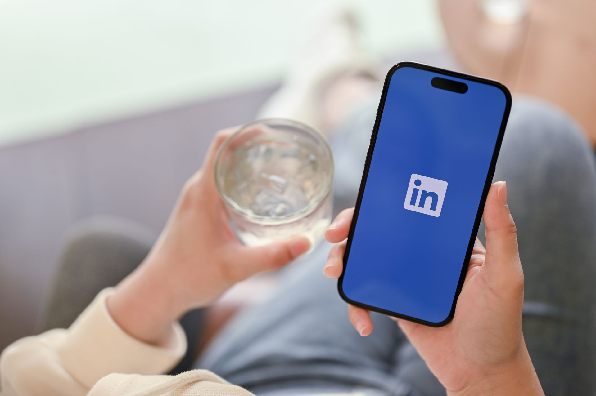 Jemand hält ein Handy mit Linked-In geöffnet