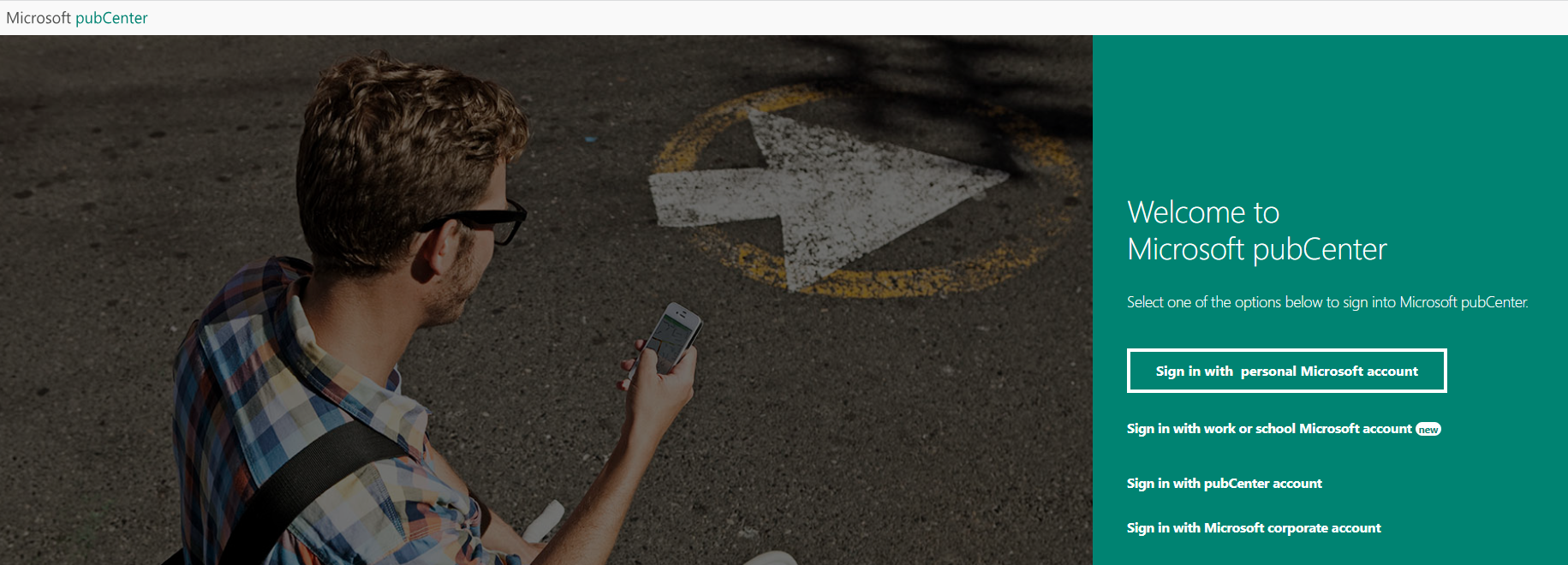 Mann hält ein Telefon neben einem Pfeil auf der Strasse. „Willkommen bei Microsoft Publisher.“