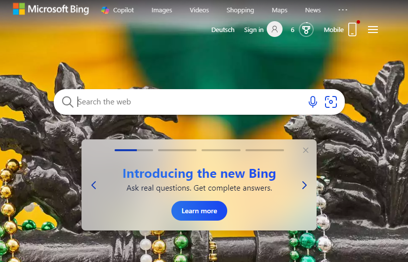Microsoft Bing-Suchseite mit einem Banner für das neue Bing über Karnevalsperlen und Hintergrund.