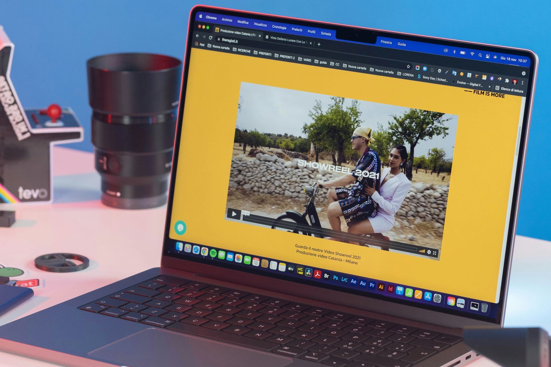 Person, die einen Laptop benutzt, wahrscheinlich Daten analysiert, mit einer Uhr, neben einem Telefon. Eine weitere Person ist im Hintergrund zu sehen.