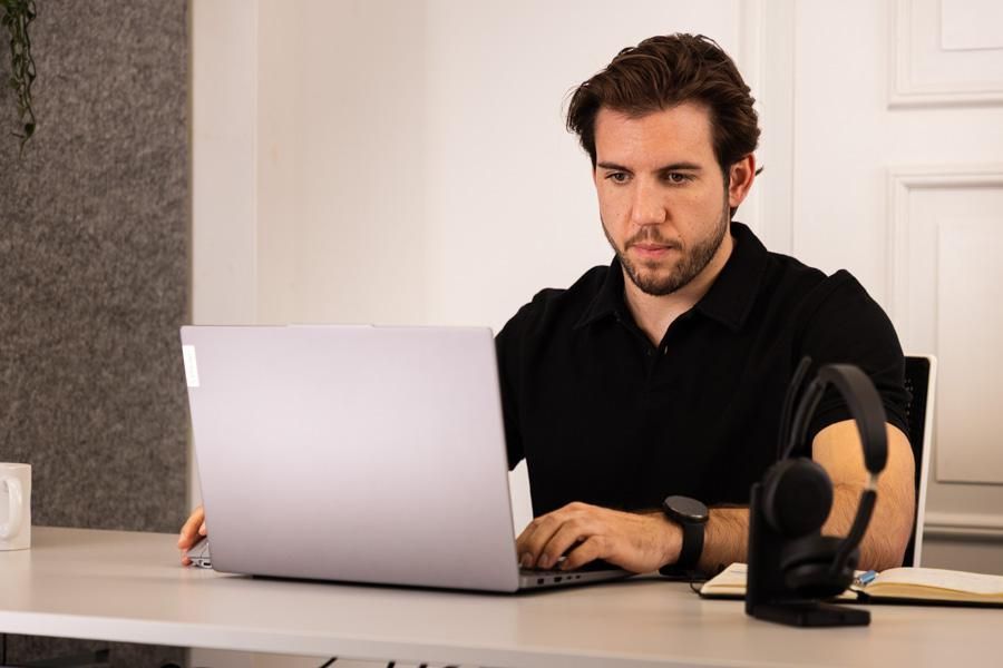 Ein Mann sitzt am Laptop und arbeitet konzentriert
