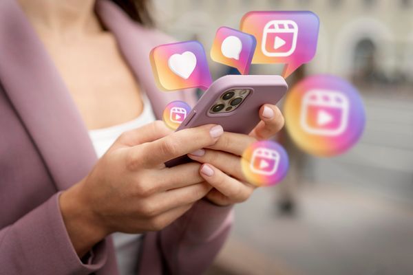 Eine Person, die ein Smartphone benutzt, daneben schwebende Instagram Symbole.