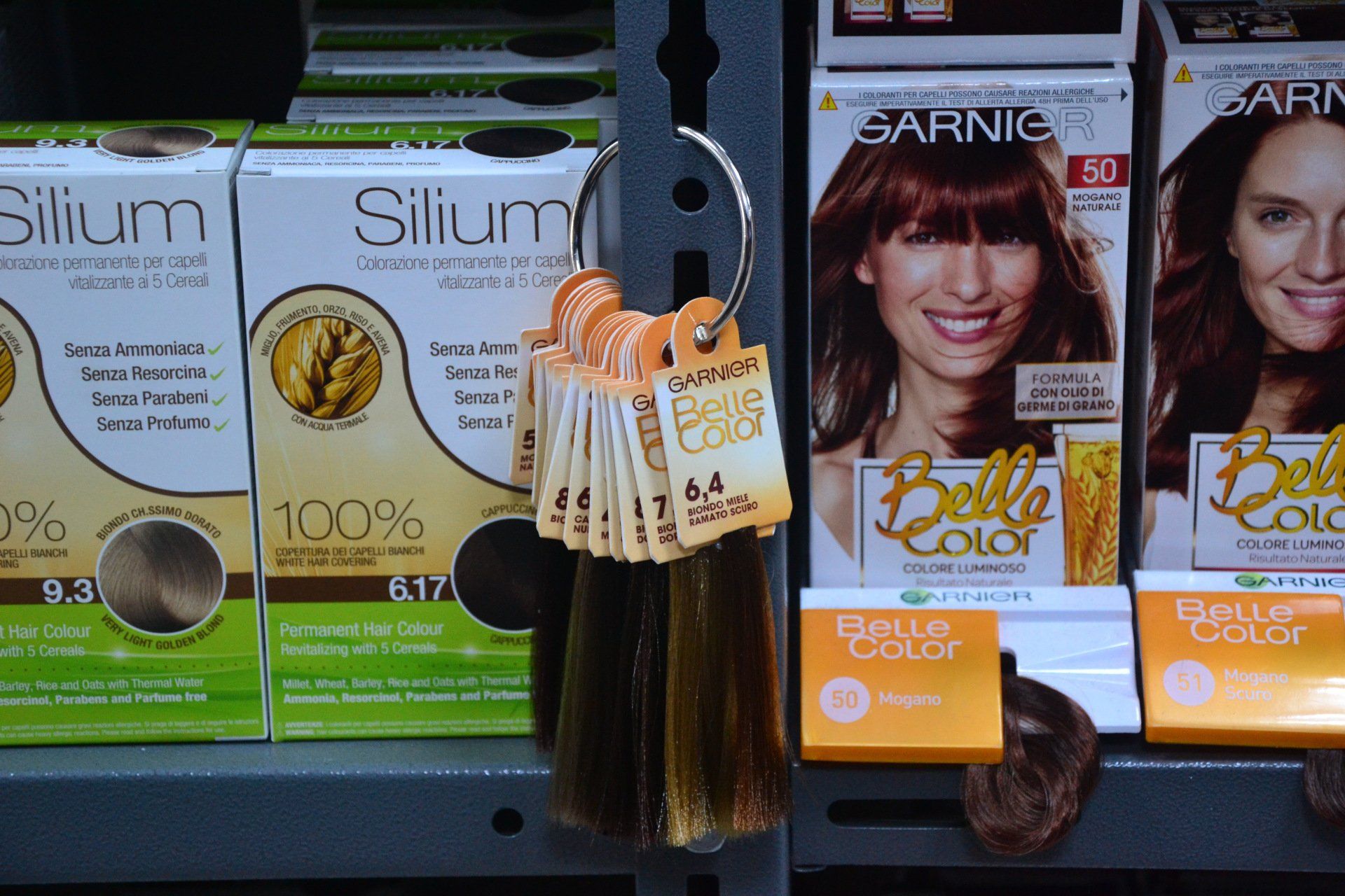 Scatole di tinture per capelli e campioni di colore sullo scaffale di un negozio.