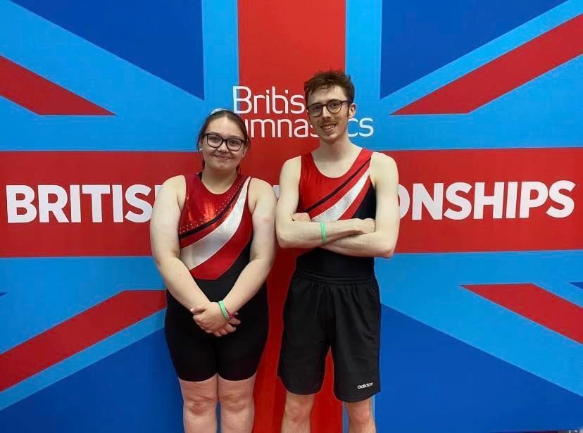 A boy and a girl are standing in front of a british flag.