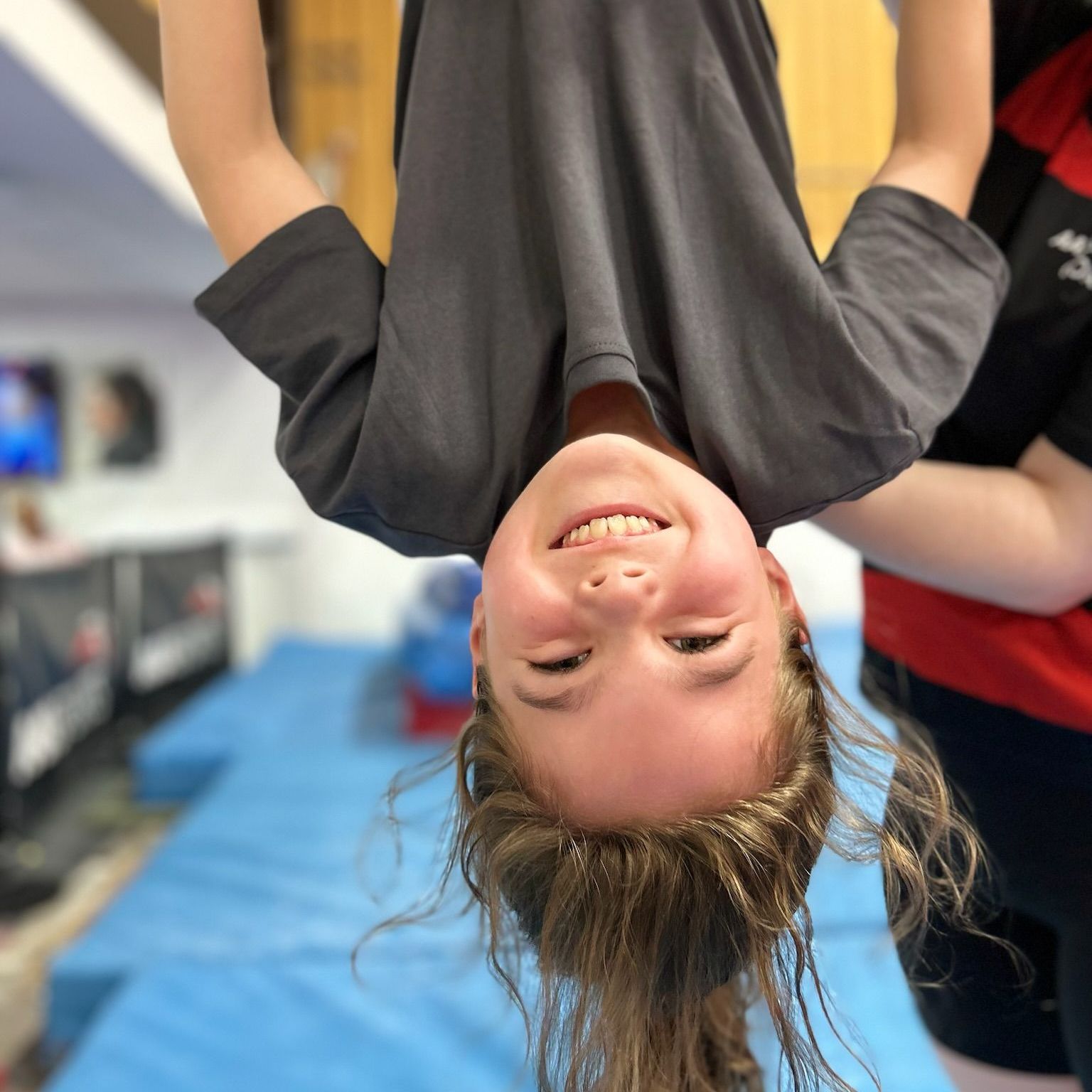 A girl is hanging upside down and smiling