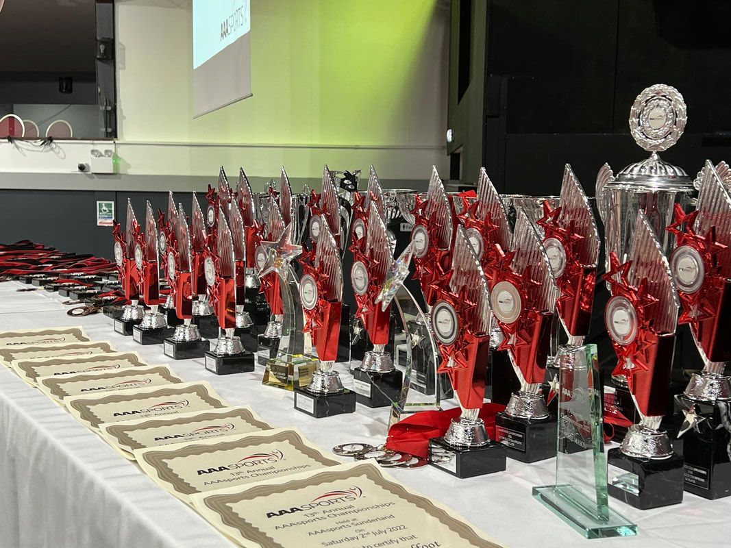 A long table filled with trophies and certificates.