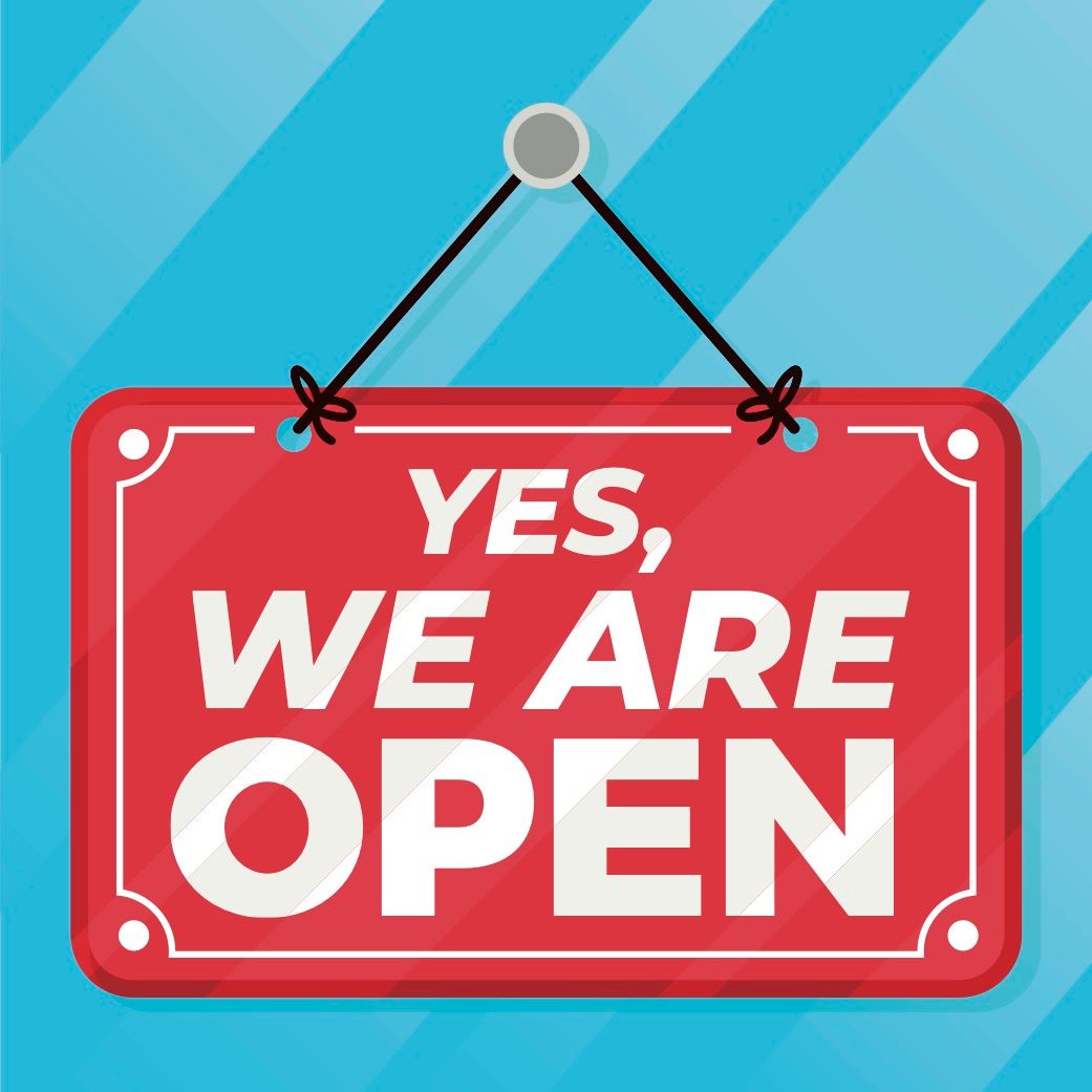 A red sign that says yes we are open