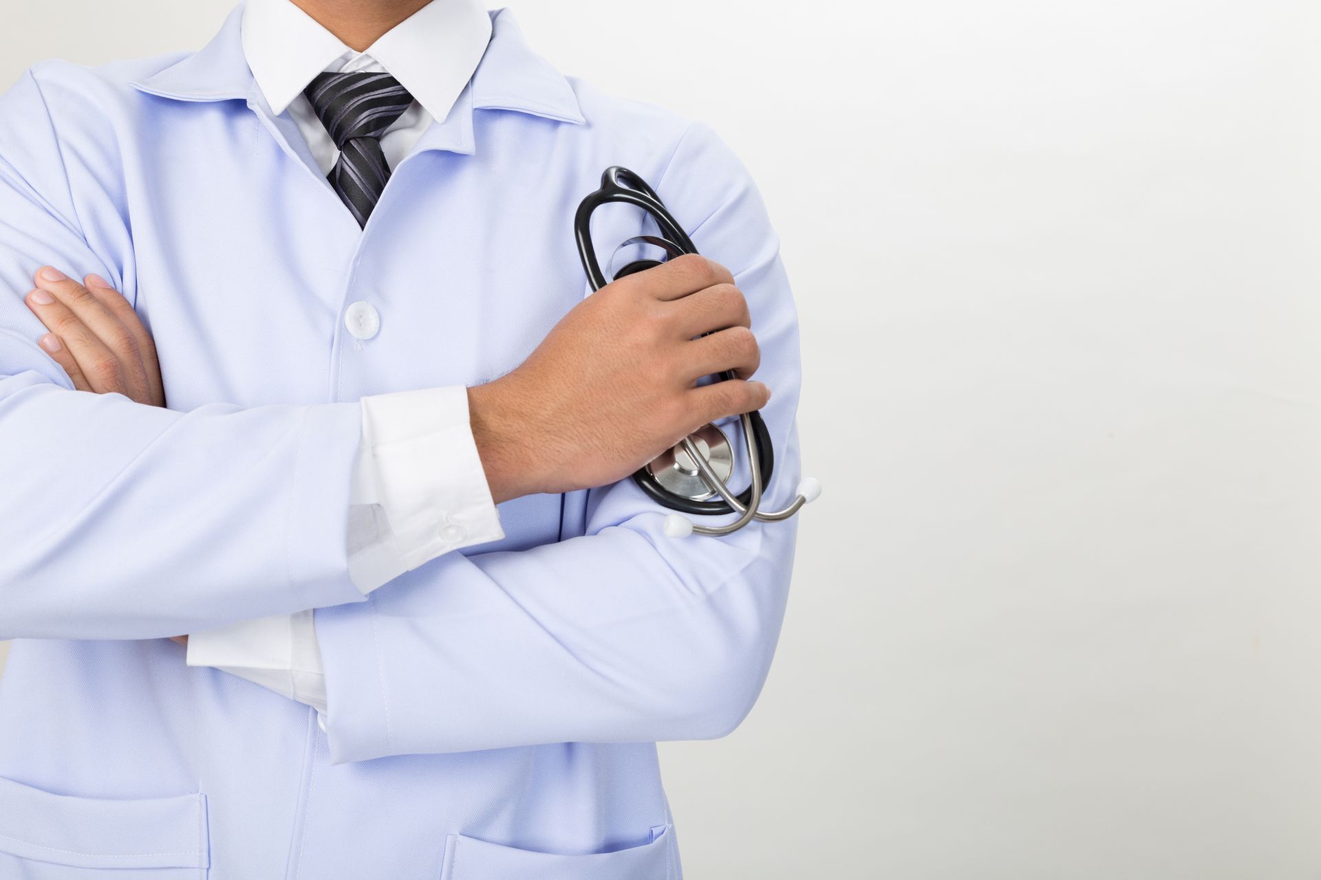 Young doctor holding stethoscope, showcasing expertise at an urgent care center.