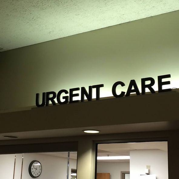 Urgent Care sign above entrance with clock and room visible inside.