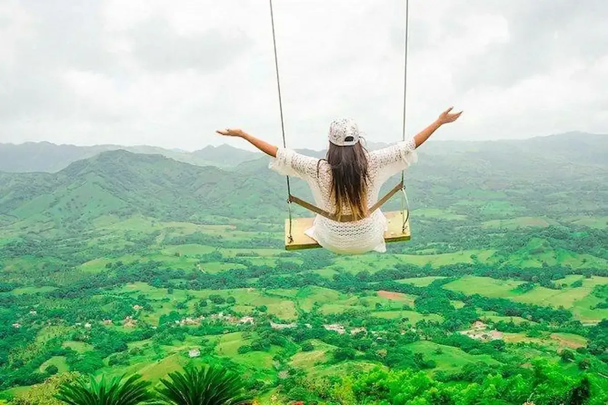 Woman on a swing enjoying the panoramic view from Montaña Redonda in Miches, Dominican Republic