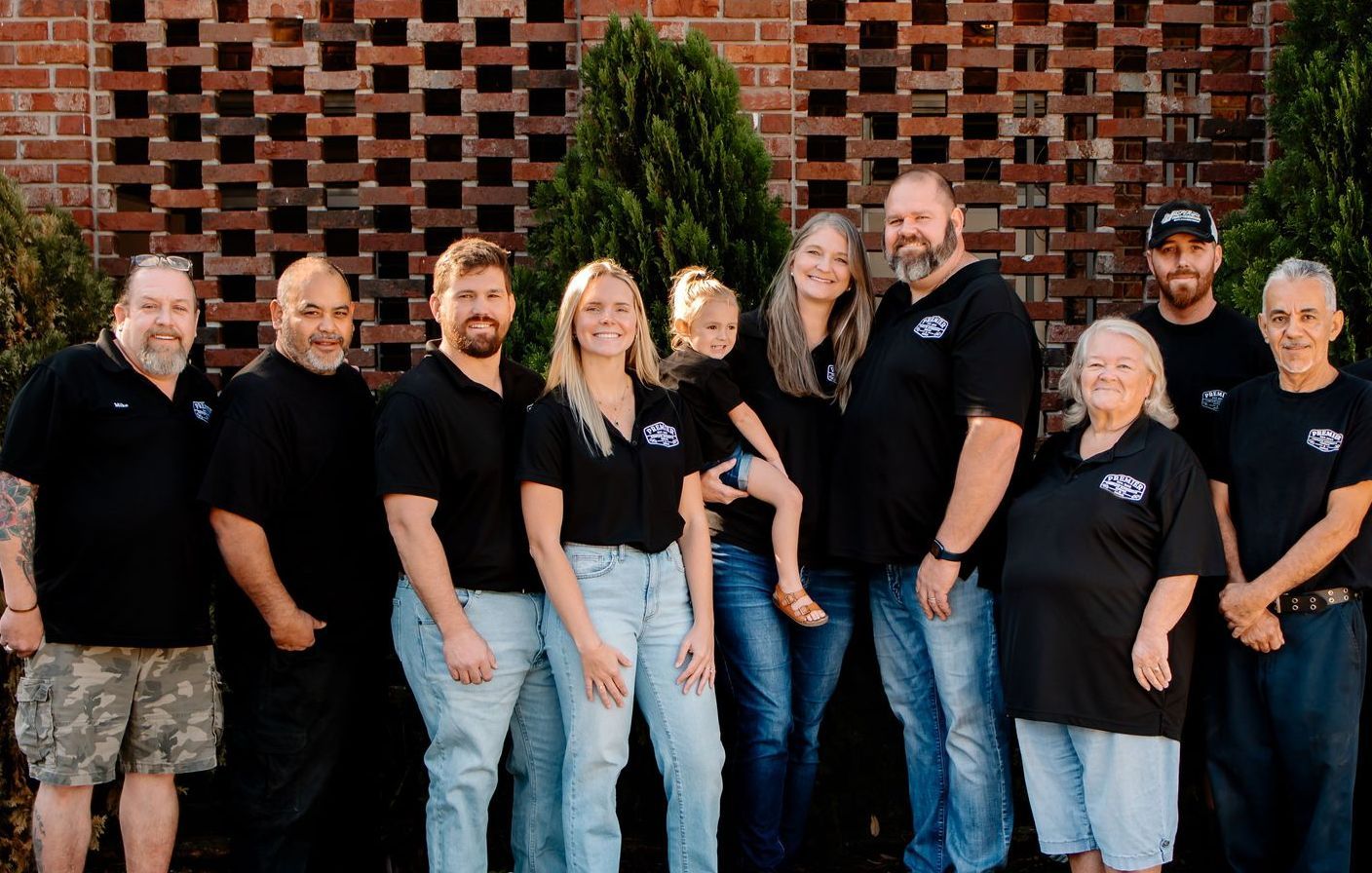 A group of people are posing for a picture in front of a building.