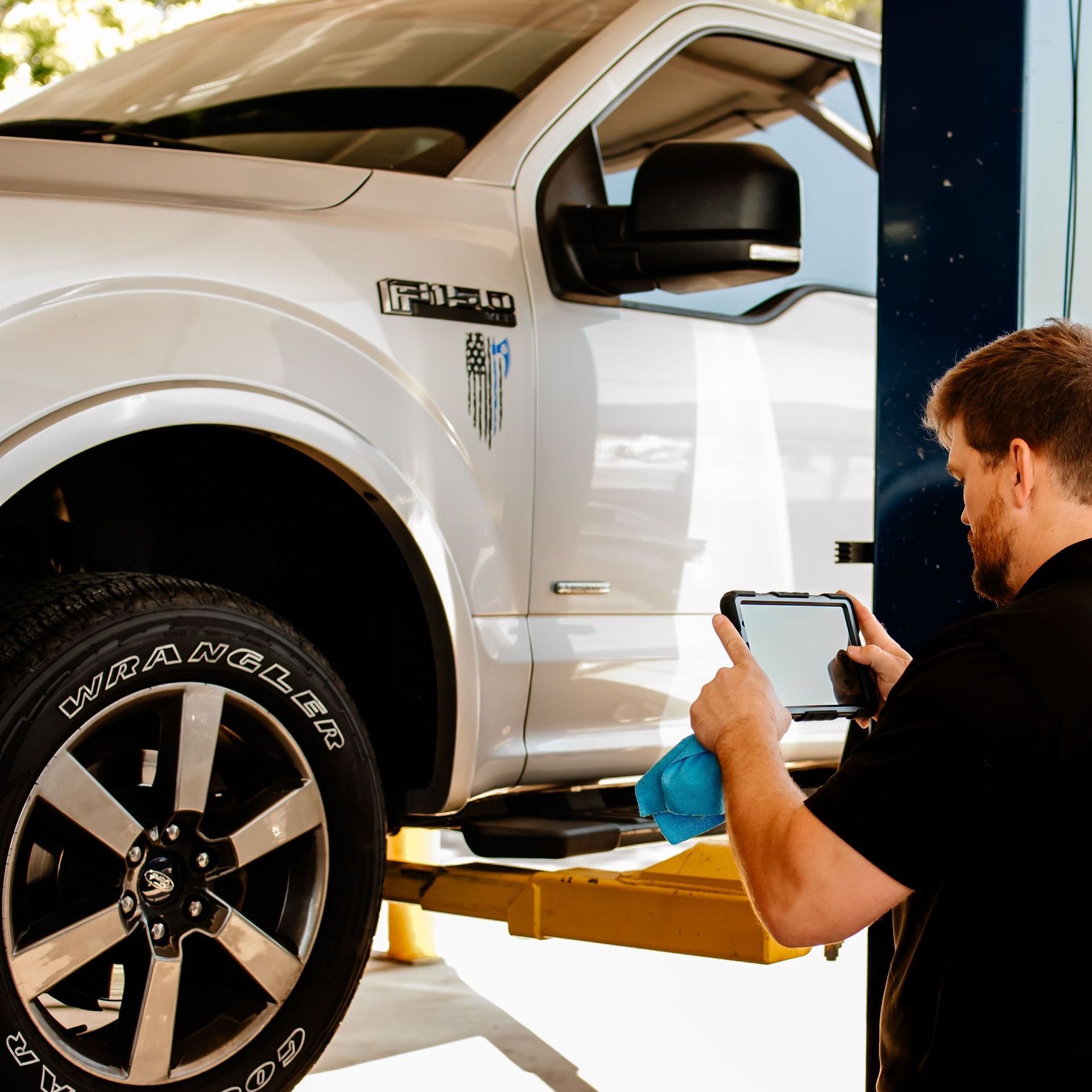 A man is working on a tire with a drill.