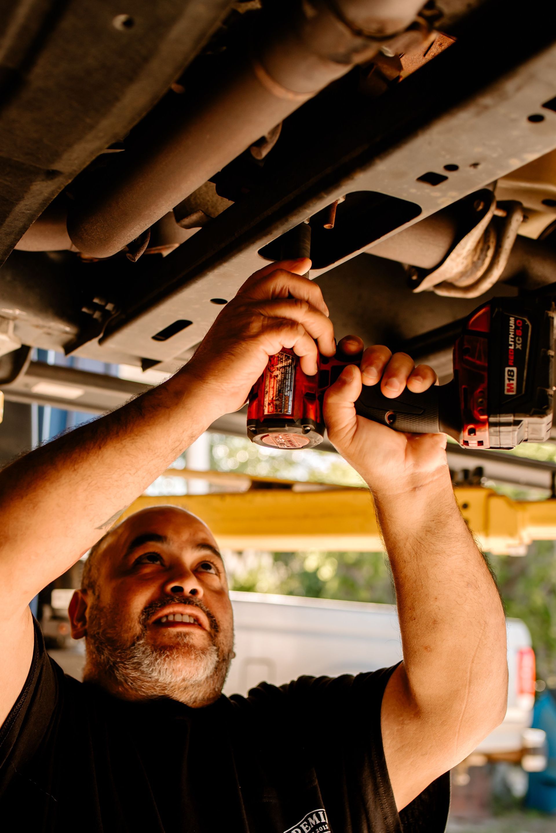 The logo for premier complete automotive service and repair is on a metal background.