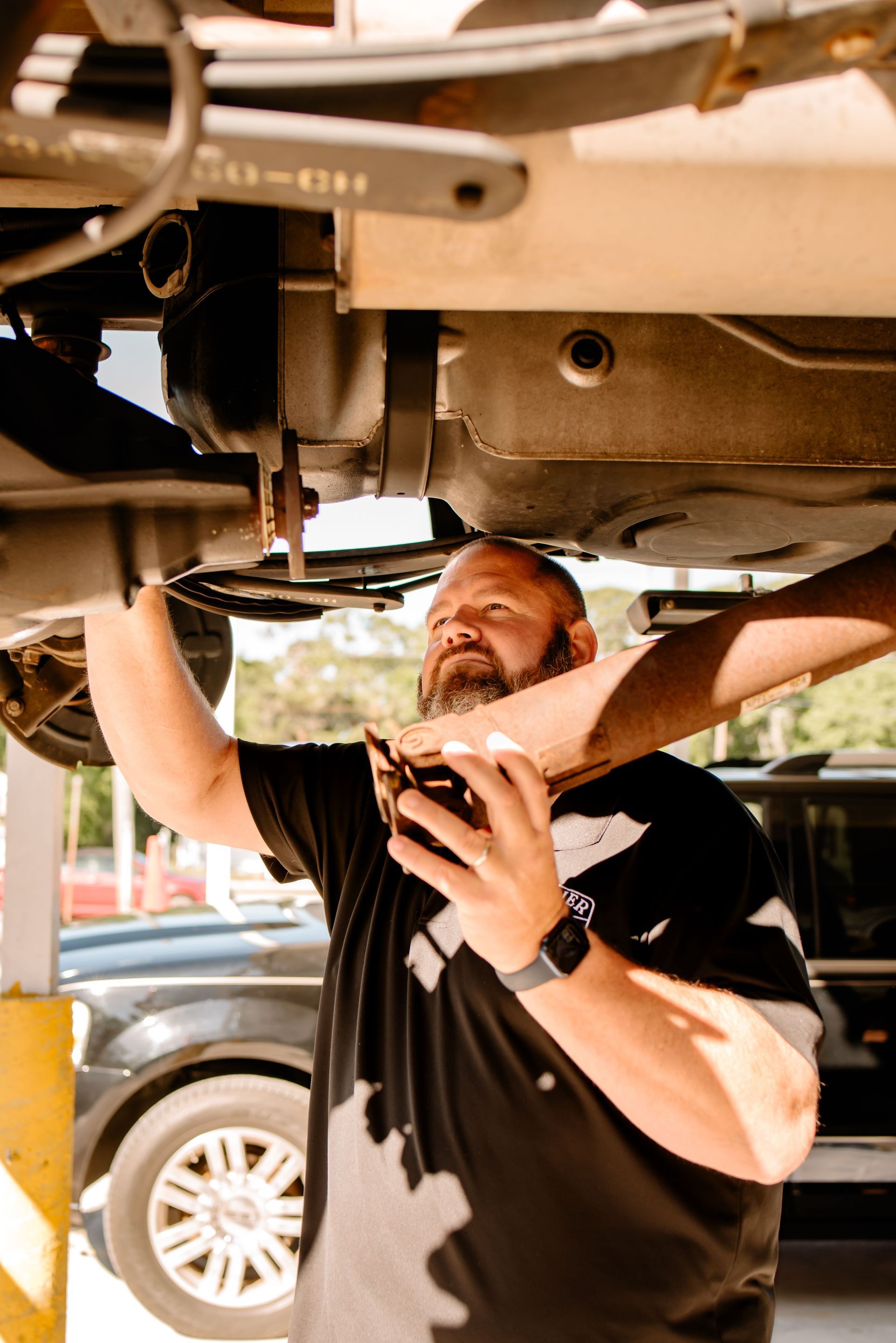 A blue car lift is sitting in front of a brick building.