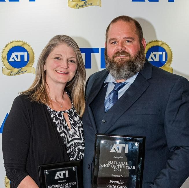 A man and a woman holding a national shop of the year award