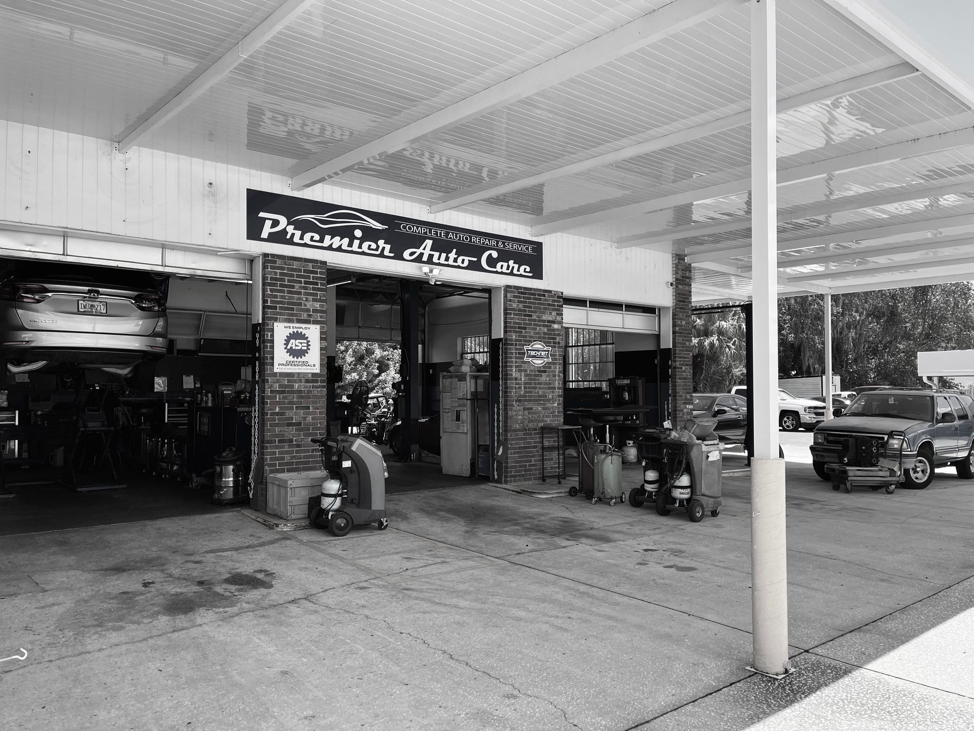 A black and white photo of a car repair shop