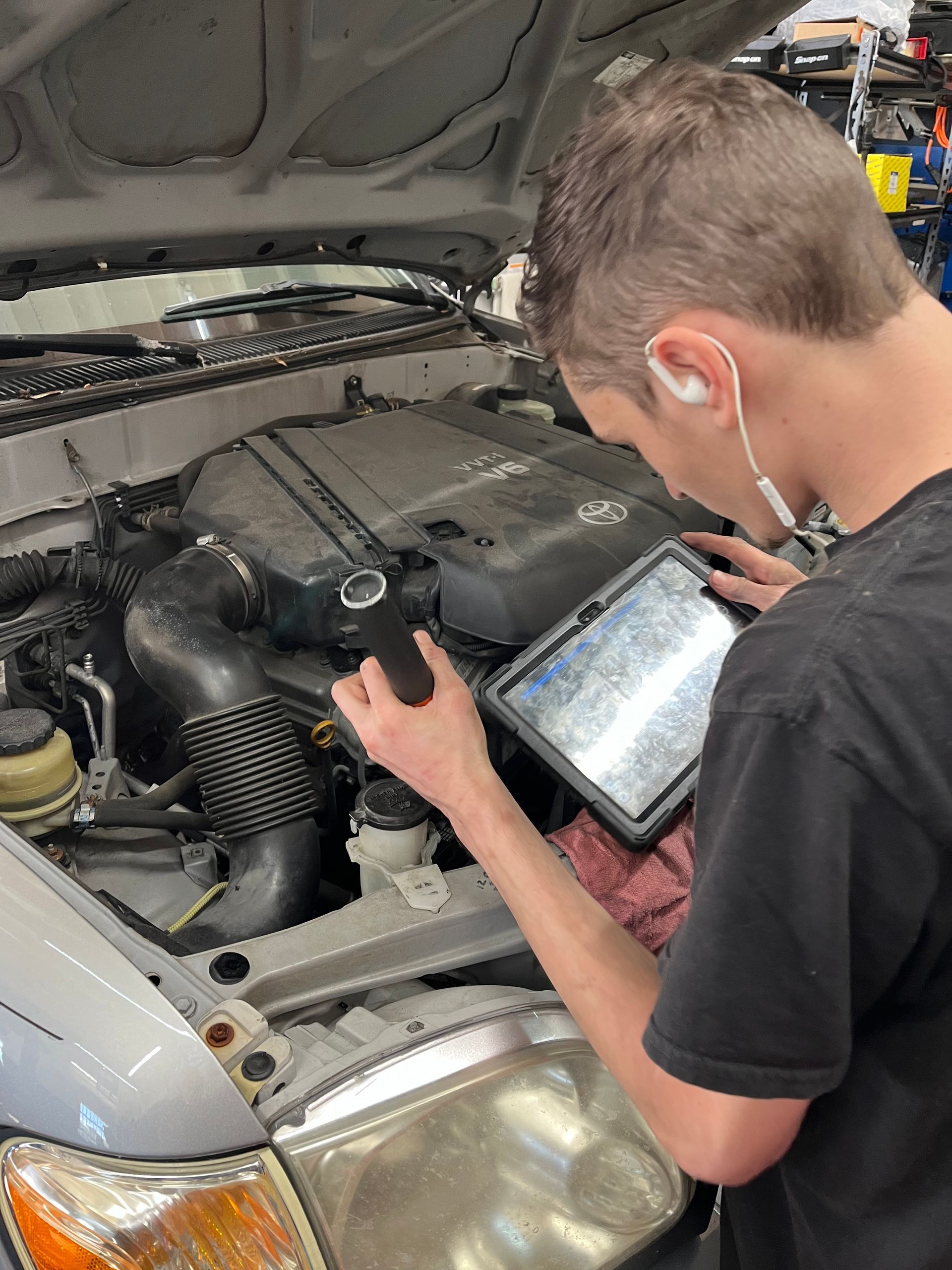 A man is working on the engine of a car.