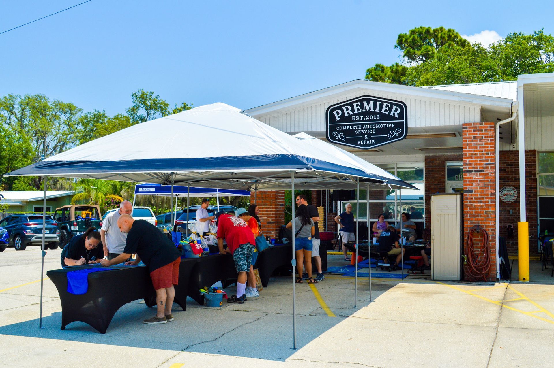 A group of people are standing under a tent in front of a building that says premio