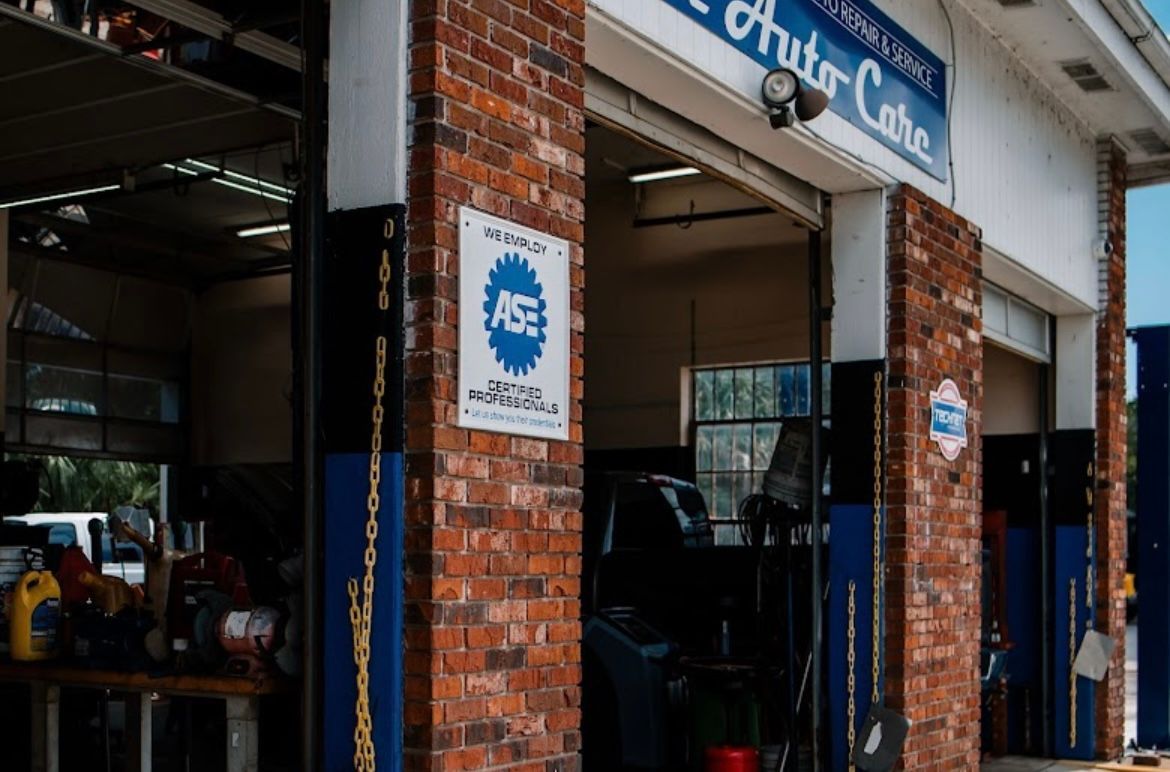 A car is parked in a garage at an auto care shop.