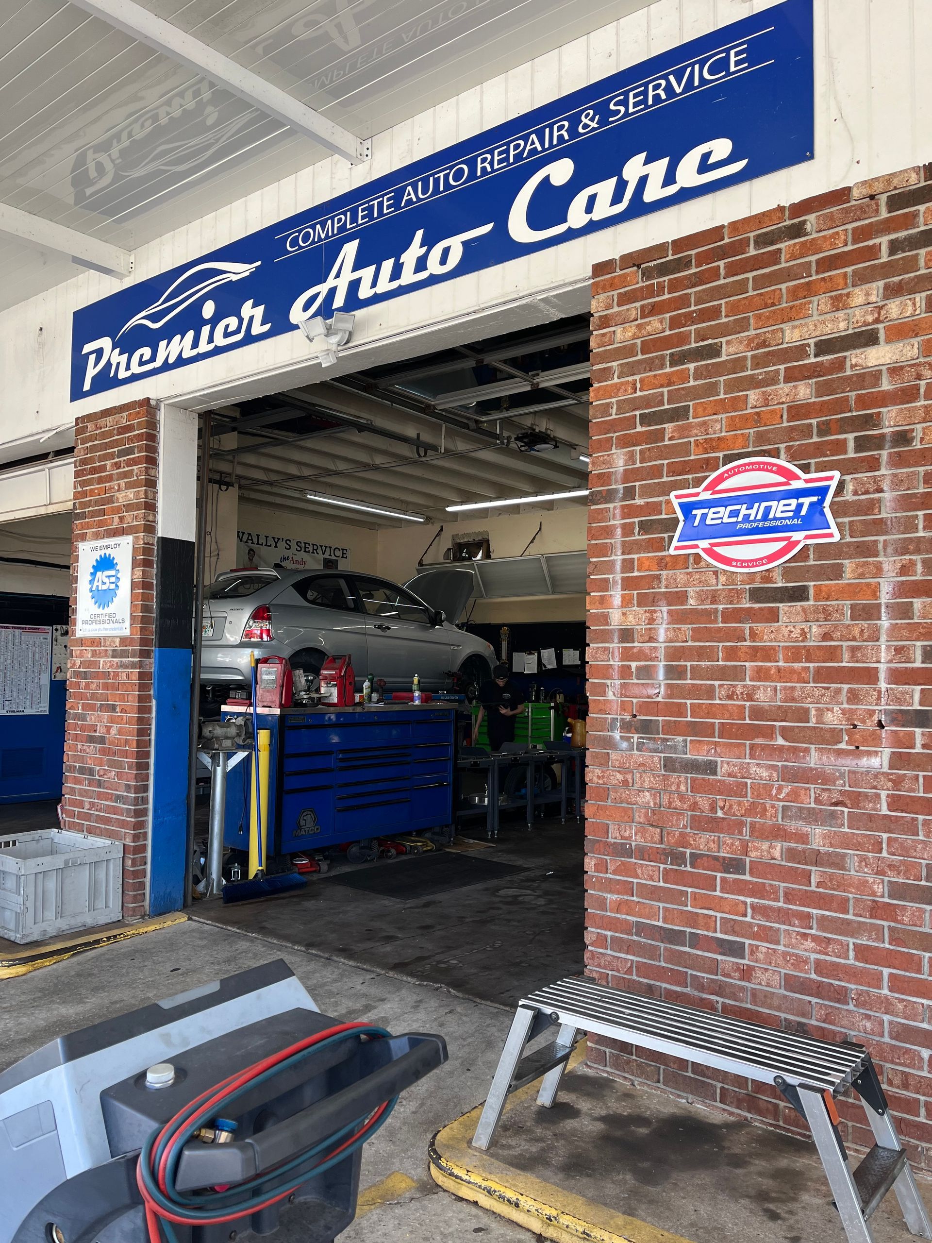 A car is being worked on in a garage at premier auto care.