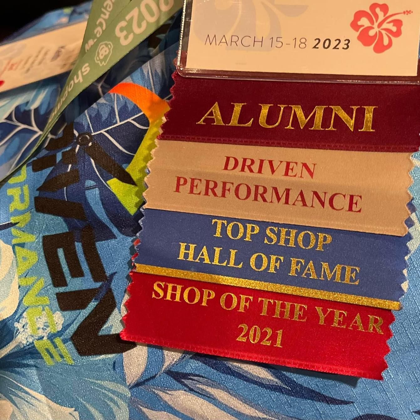 A ribbon that says alumni driven performance top shop hall of fame shop of the year 2021