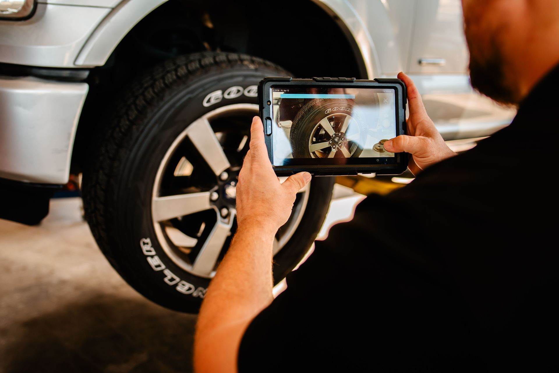 Three men are standing in front of an automotive training institute building.