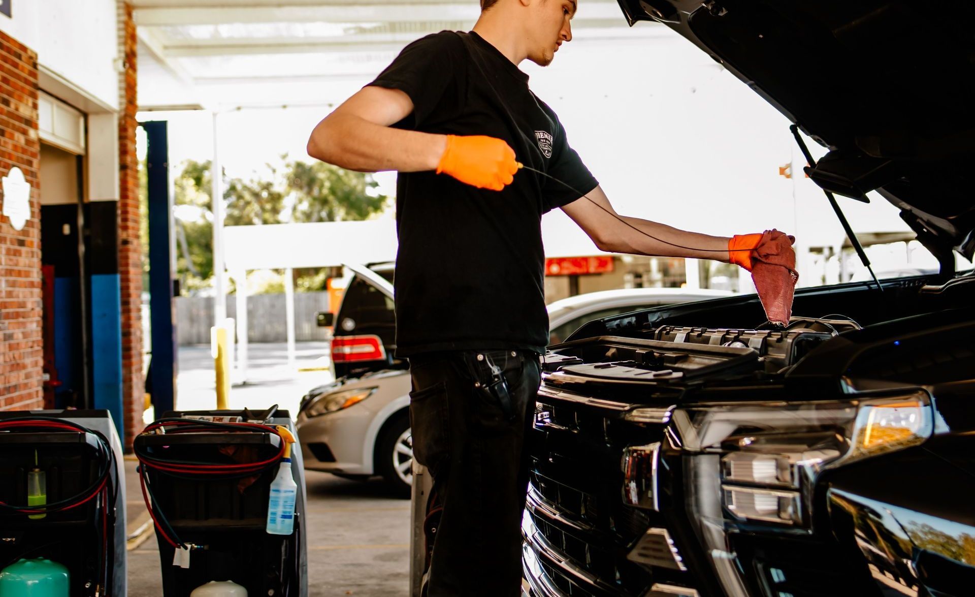 Young man at Premier Auto Care Titusville, Florida 32780 32796 Brevard county checking the cars oil