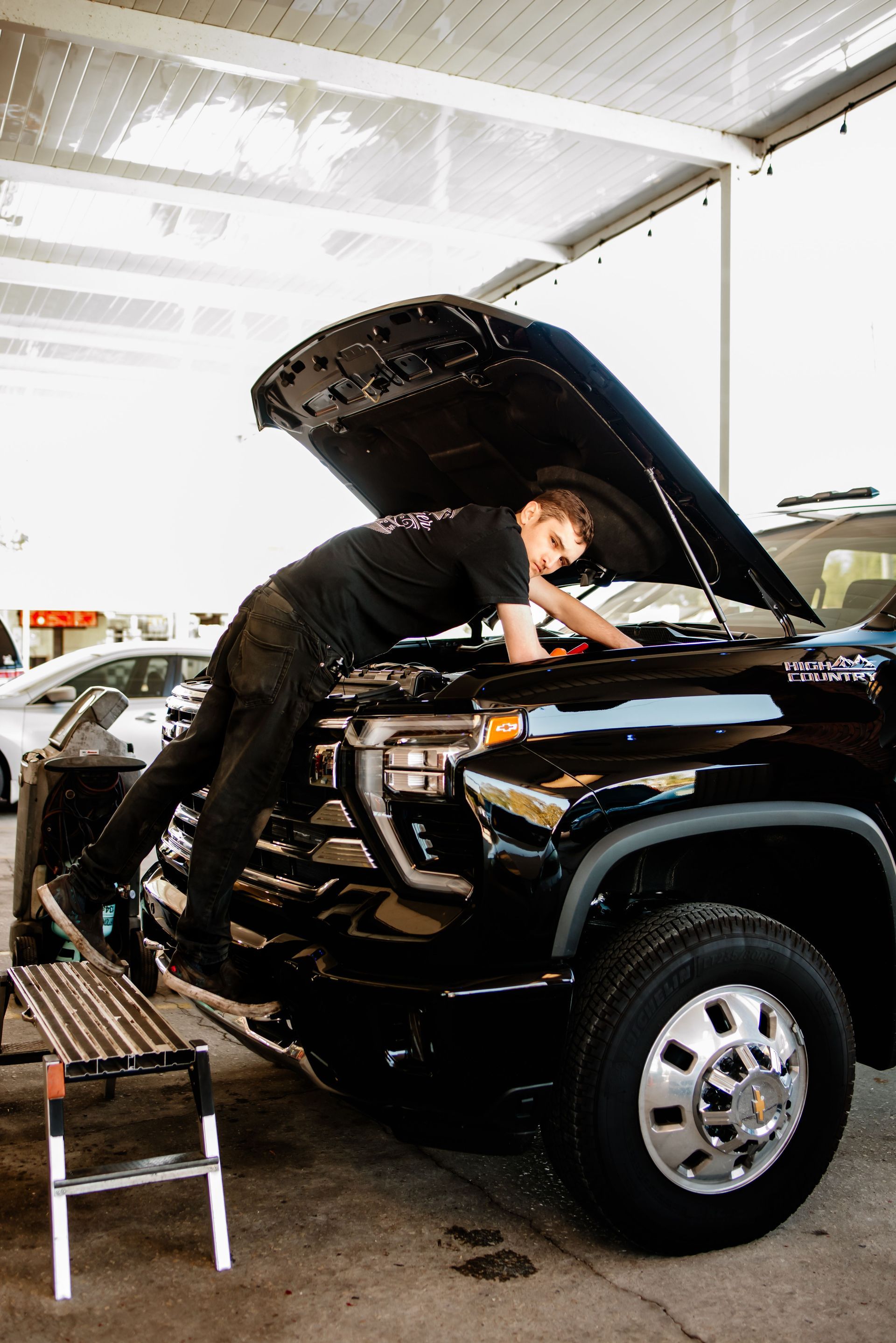 A man and two women are posing for a picture in front of a brick wall.