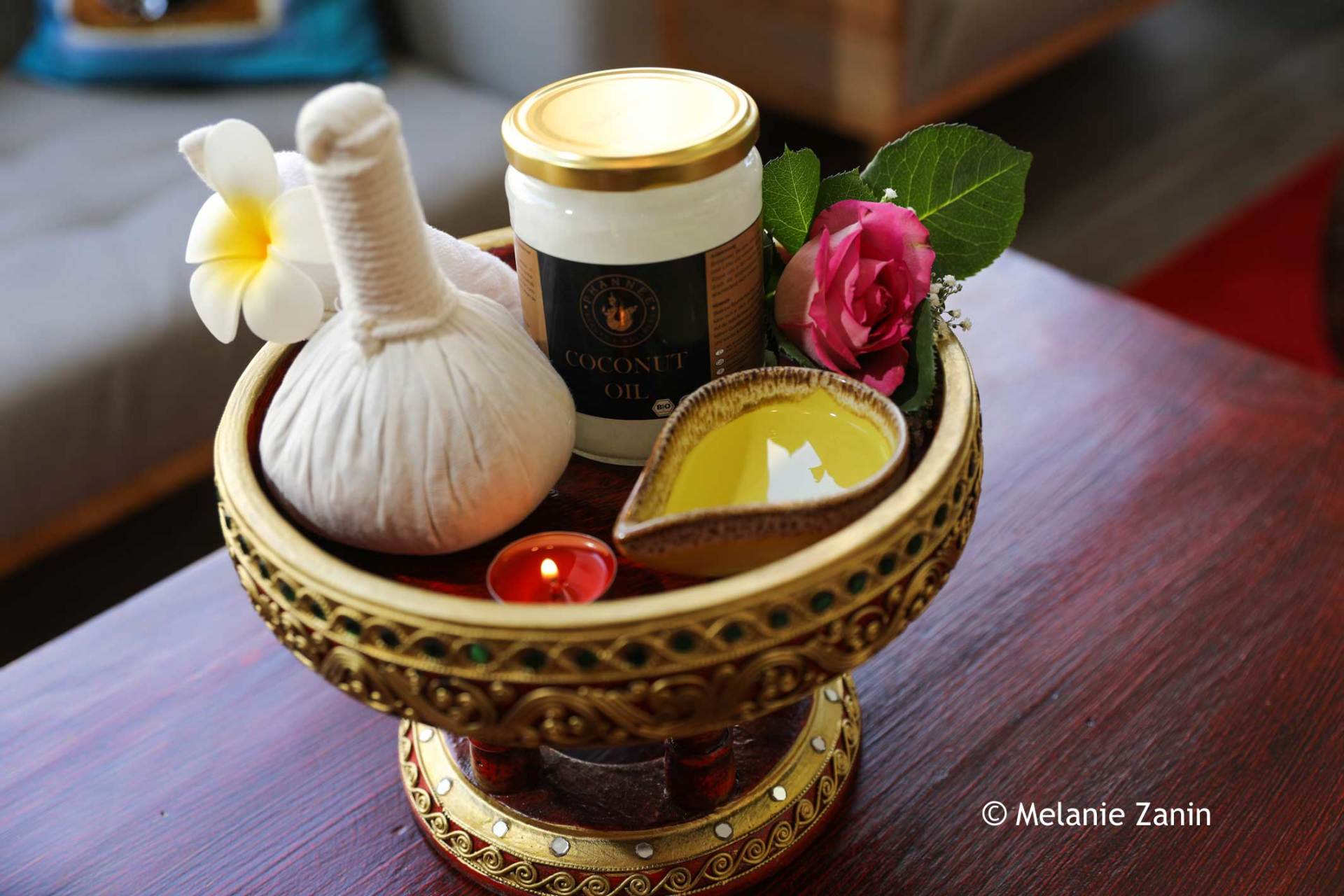 Eine Schale gefüllt mit Kerzen und Blumen auf einem Tisch.