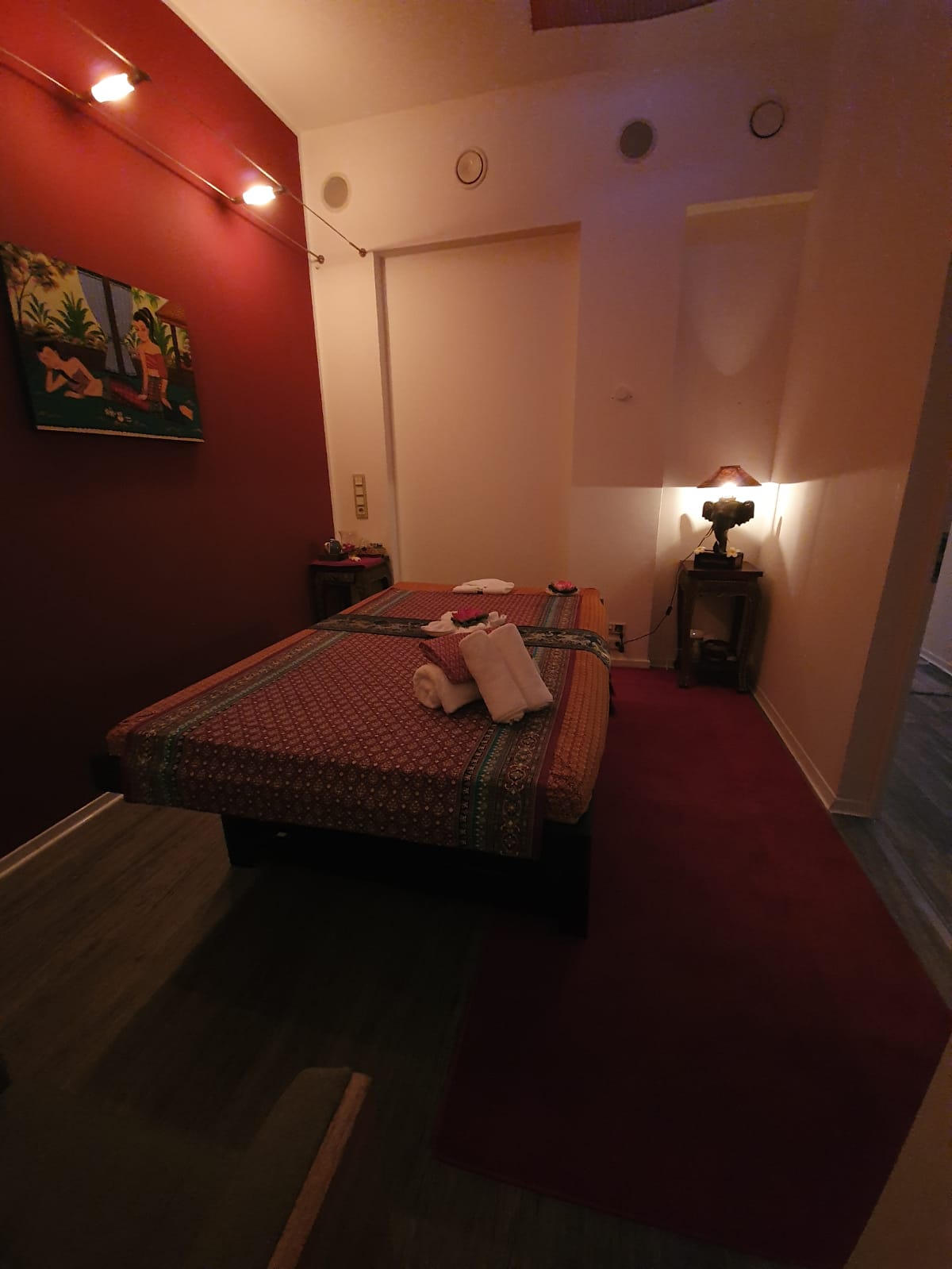 Ein Zimmer mit einem Bett und einem Gemälde an der Wand