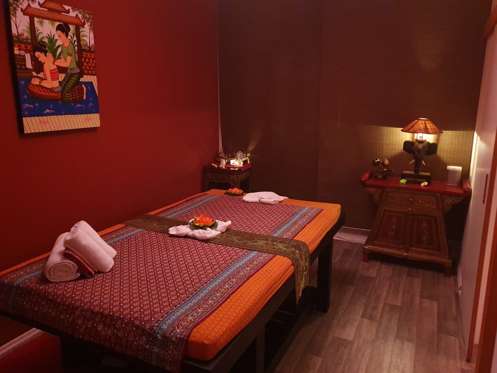 Ein Zimmer mit zwei Betten und einer Lampe darin.