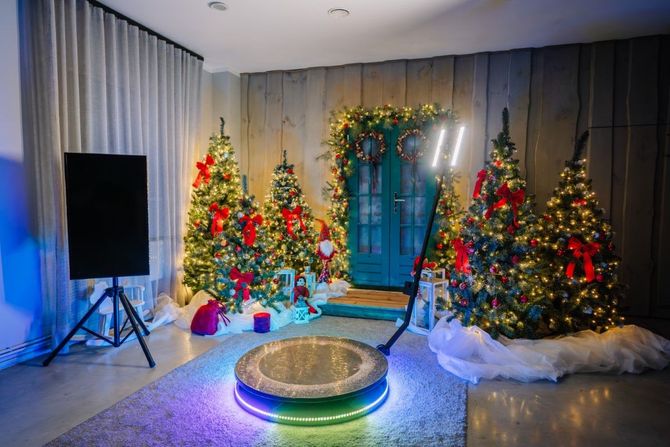 Festive holiday display with decorated Christmas trees, glowing lights, and a circular centerpiece in a room