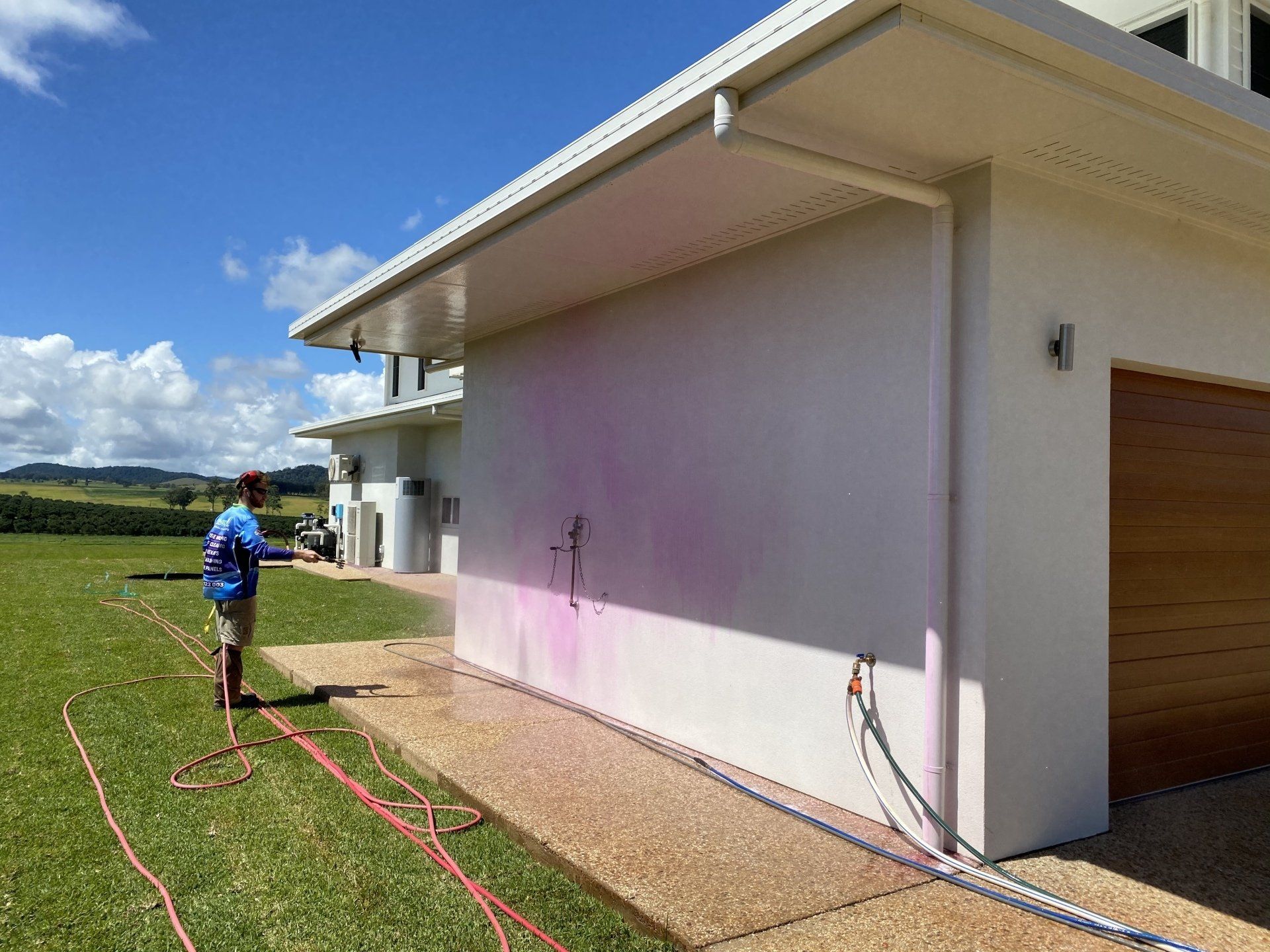 Man Cleaning The Wall Of The House — FNQ Pressure Cleaning  in Atherton, QLD