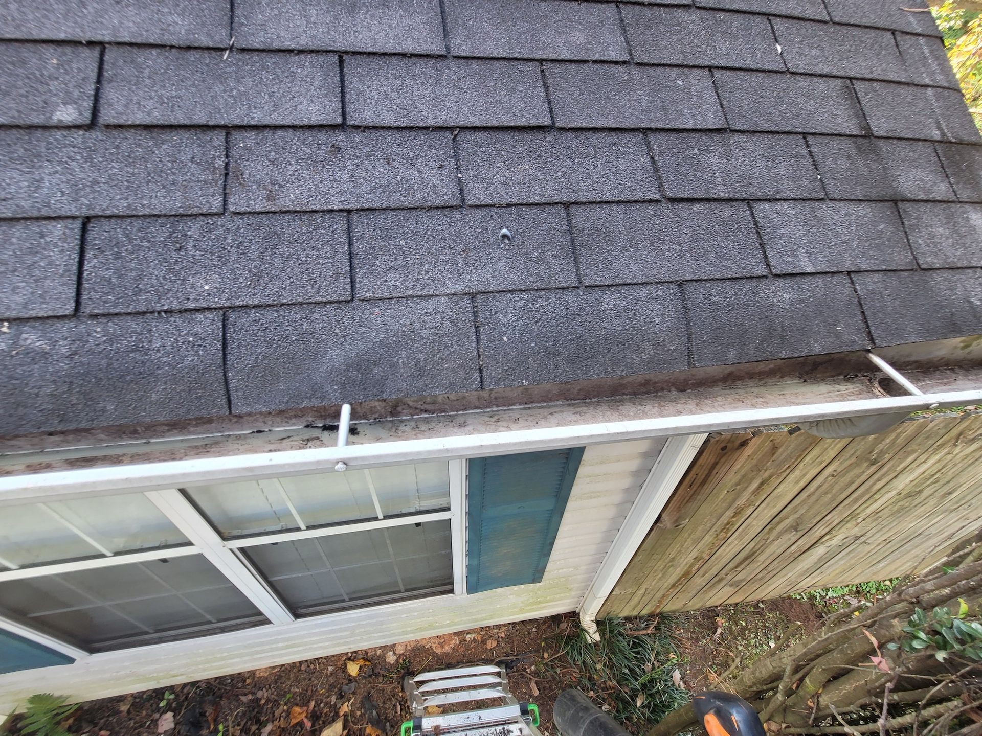 A house with a gutter on the side of it and a roof