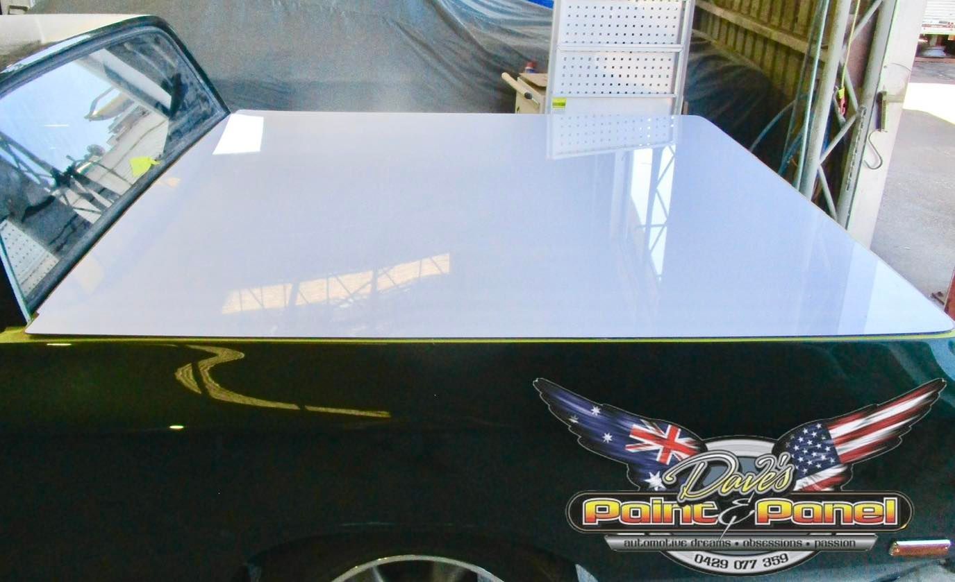 Green pickup truck bed with a silver tonneau cover; a logo is on the side.